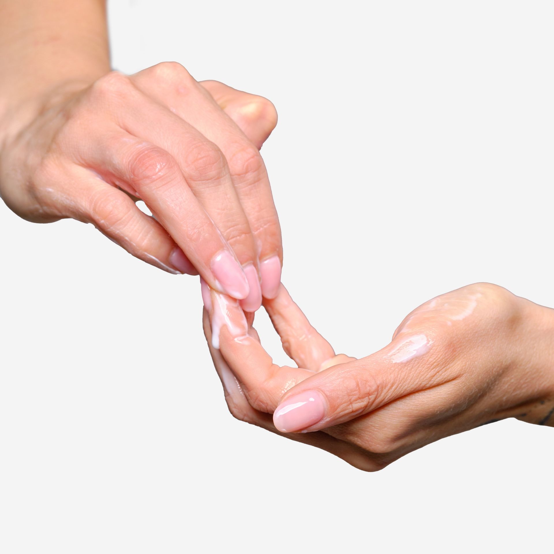 Mani che strofinano un liquido bianco. Prodotto: Latte Struccante.