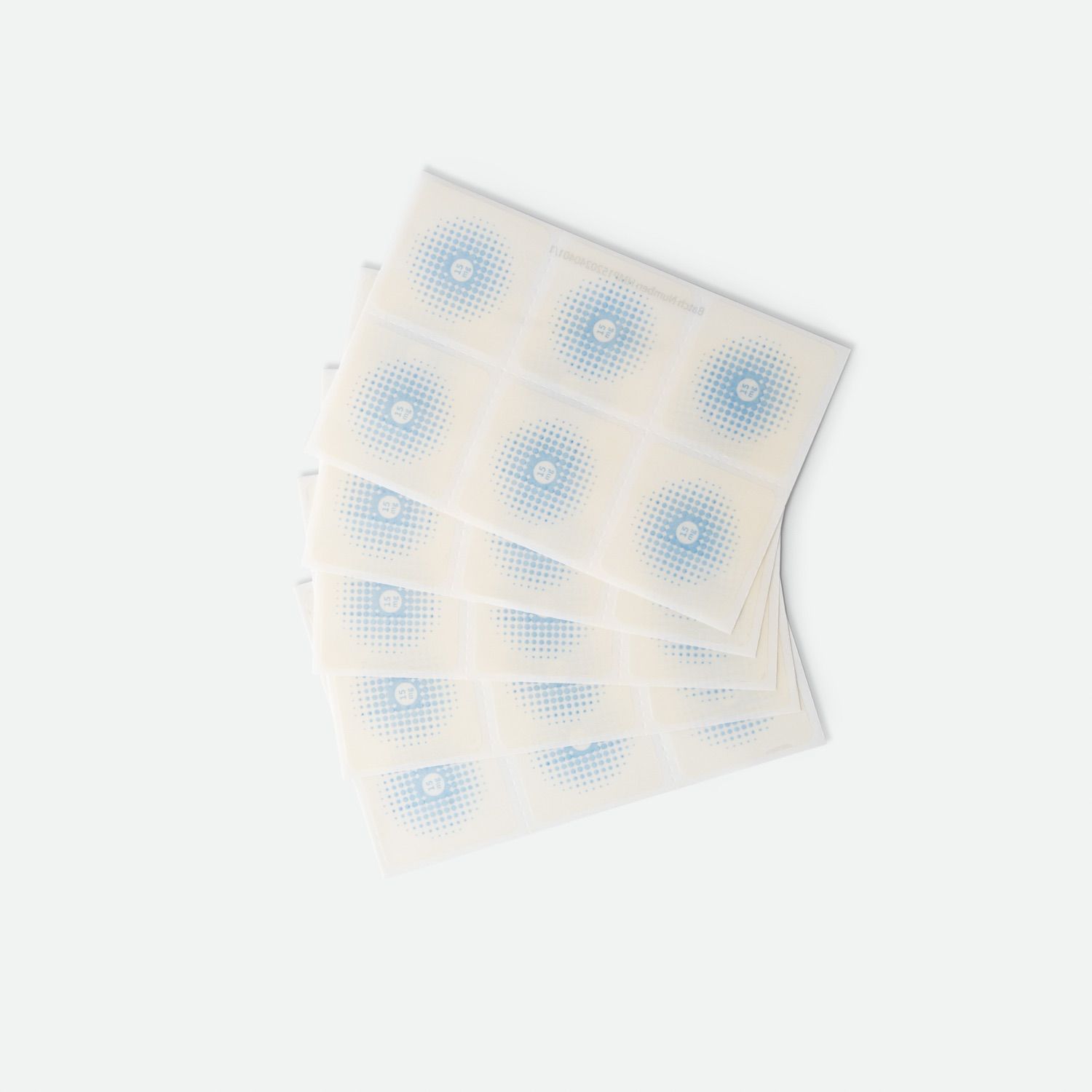 Più cerotti quadrati con motivo a punti blu. Disposti su sfondo bianco.