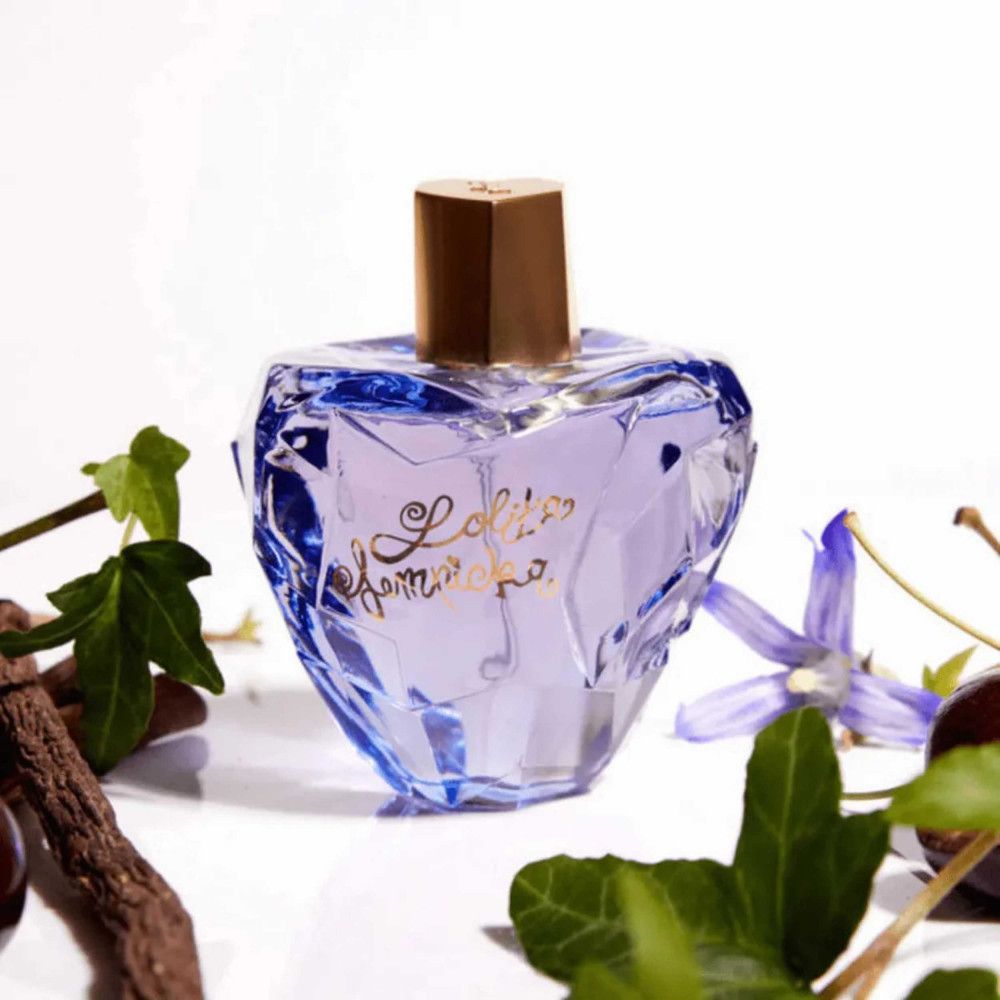 Flacone blu con tappo dorato. Circondato da foglie e ciliegie. Scritta: Lolita Lempicka.