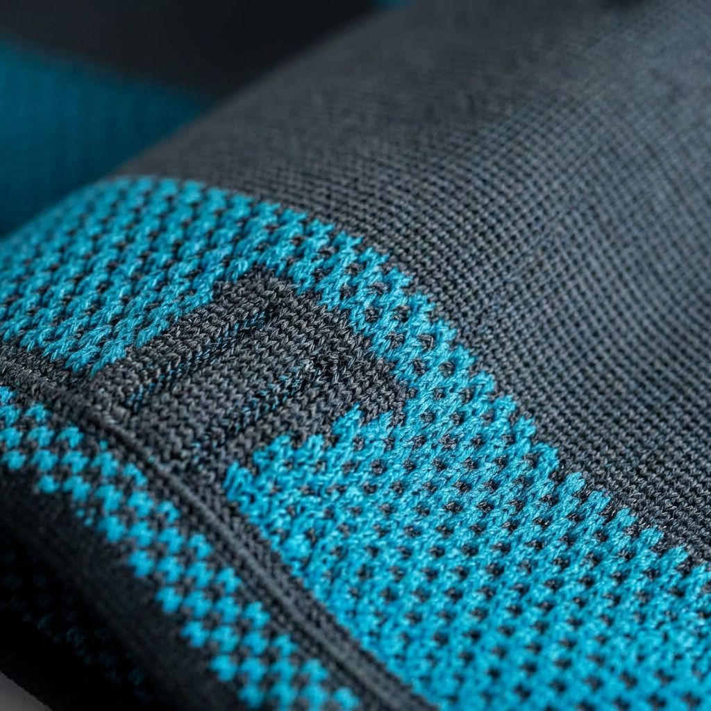 Primo piano del bendaggio per coscia. Tessuto blu e nero. Motivo quadrato. Vista dettagliata.