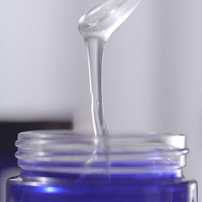 Gel che gocciola da un'apertura. Chiaro, trasparente. Sfondo chiaro.