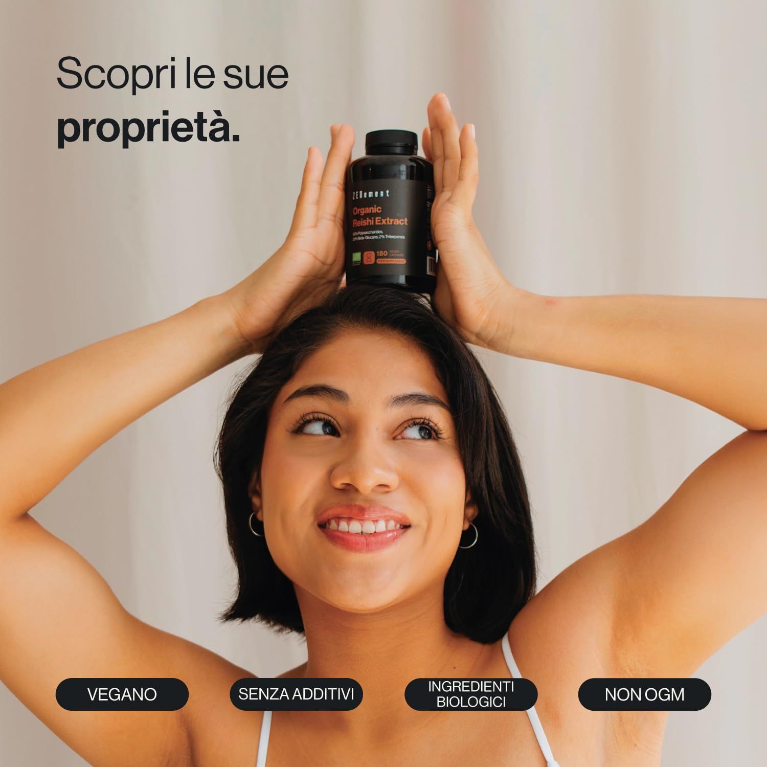 Una donna tiene una bottiglia di capsule sulla testa. La bottiglia riporta la scritta "Zenement Bio Reishi Extrakt".
