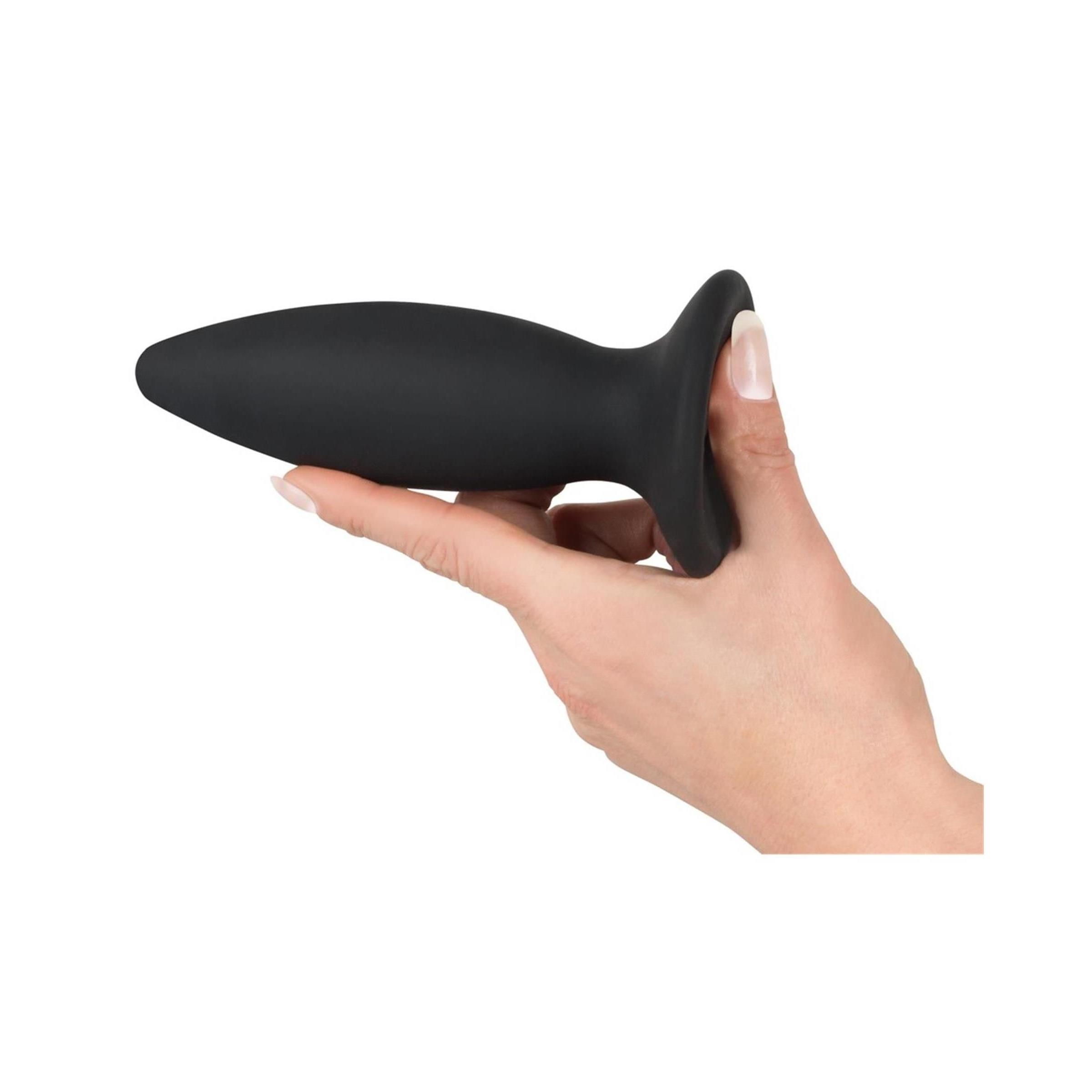 Plug nero tenuto in mano. Conico con base ampia.