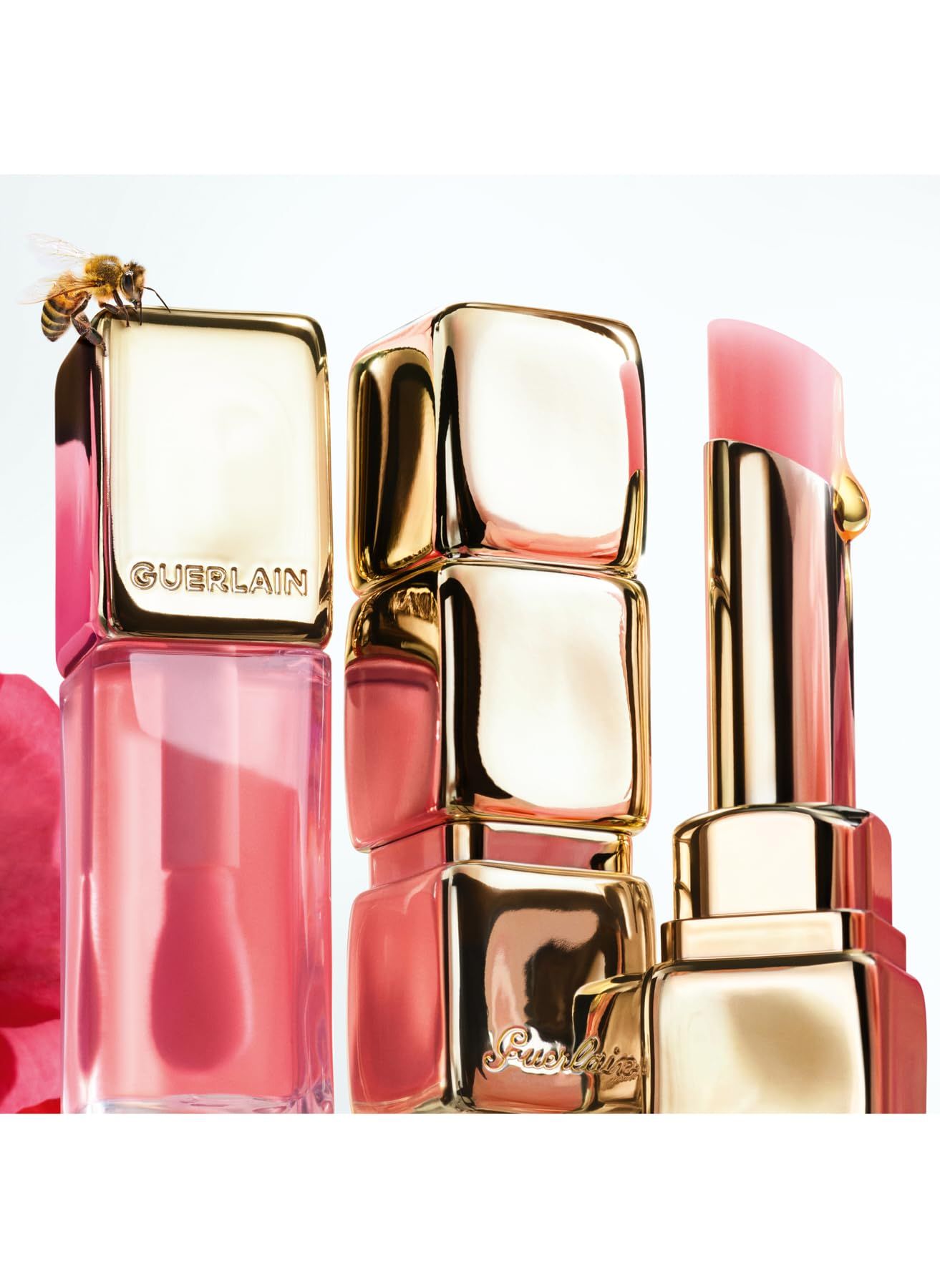 Diverse confezioni di balsamo per le labbra in oro e rosa, con un'ape su una confezione.