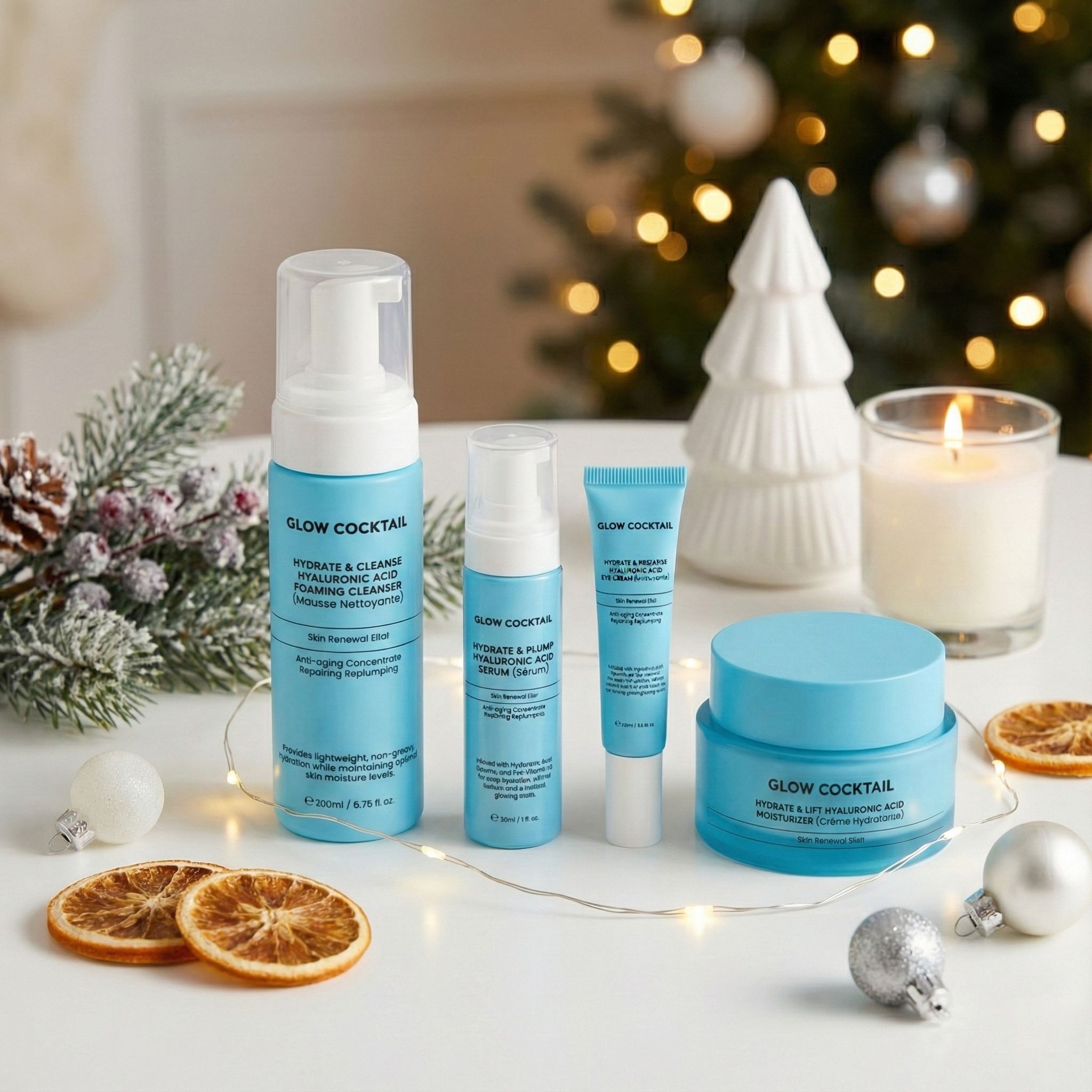 Set per la cura della pelle Glow Cocktail su tavolo. Con decorazioni natalizie. Contiene detergente, siero, idratante e crema.