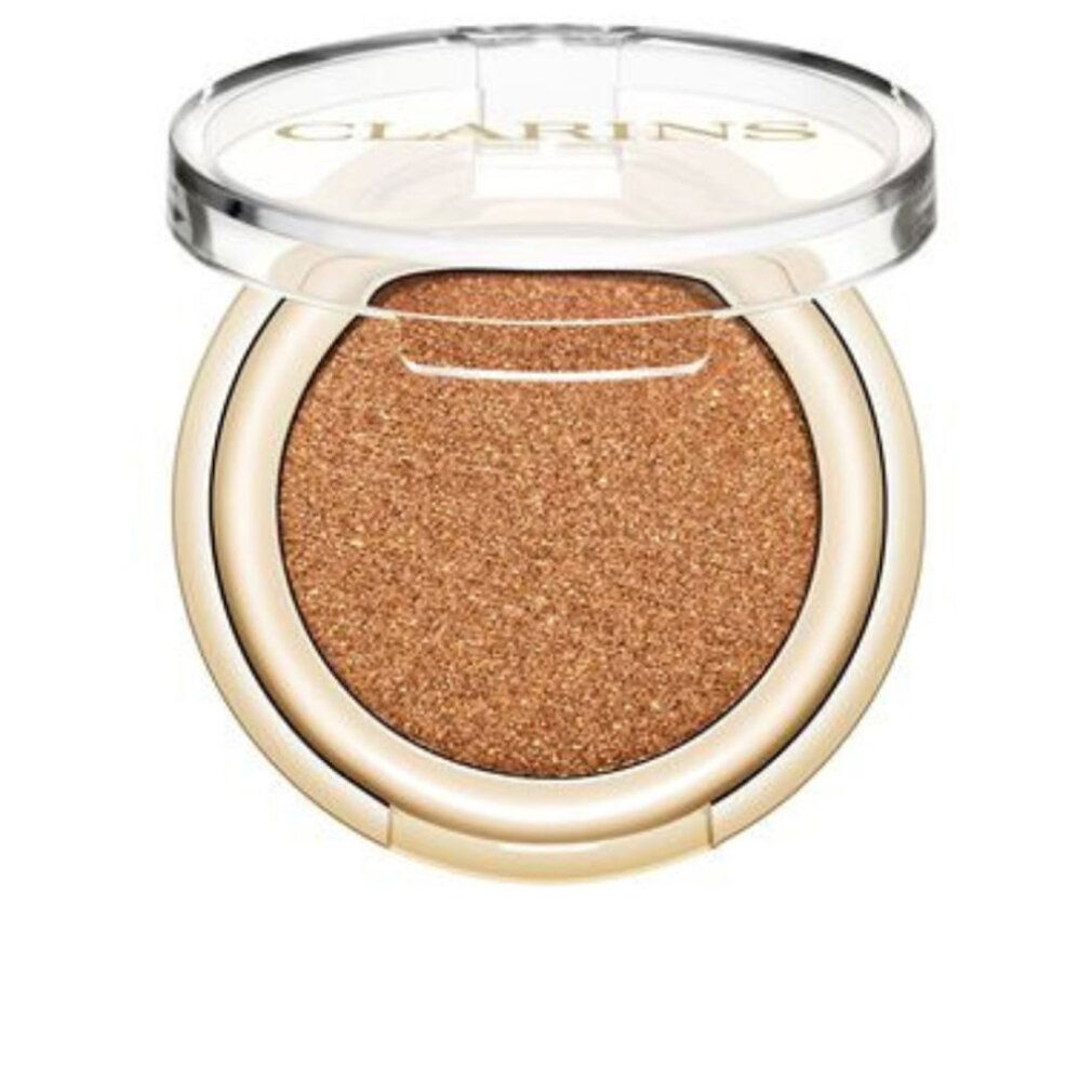 Ombretto Clarins. Astuccio rotondo dorato con ombretto dorato. Coperchio trasparente con logo Clarins.