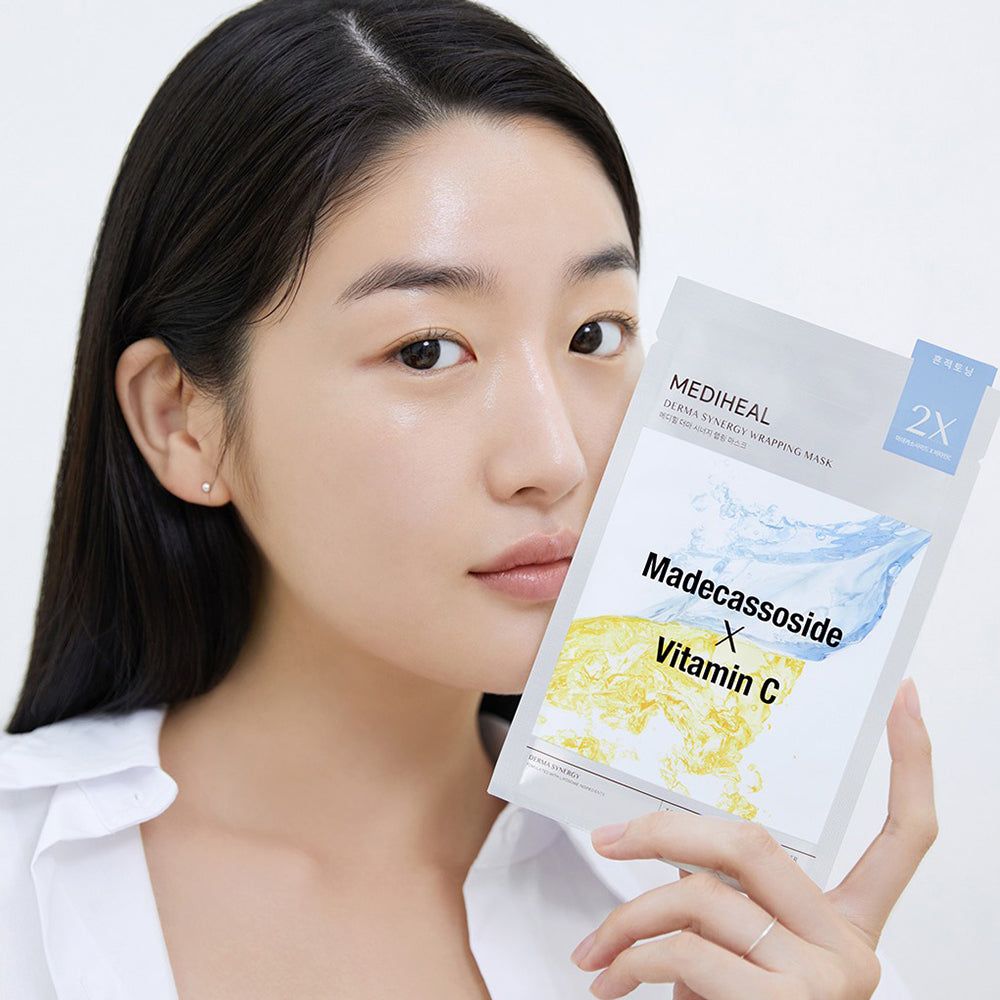Donna tiene confezione maschera viso. Scritta: Madecassoside X Vitamin C. Marchio: MEDIHEAL Derma Synergy Wrapping Mask.