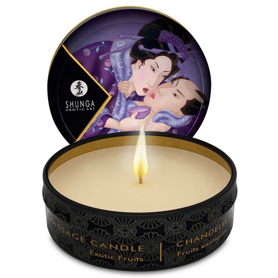Candela da massaggio accesa in scatola nera, arte erotica sul coperchio, scritta 'Massage Candle Exotic Fruits'.