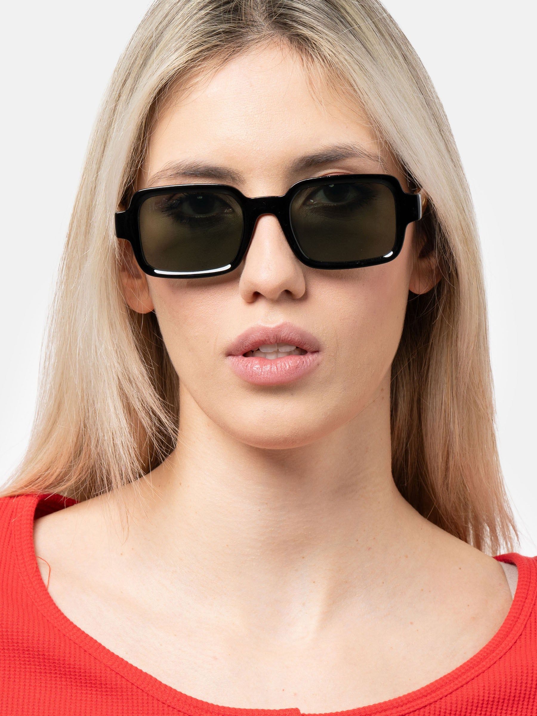 Donna con occhiali da sole neri con lenti rettangolari. Top rosso.