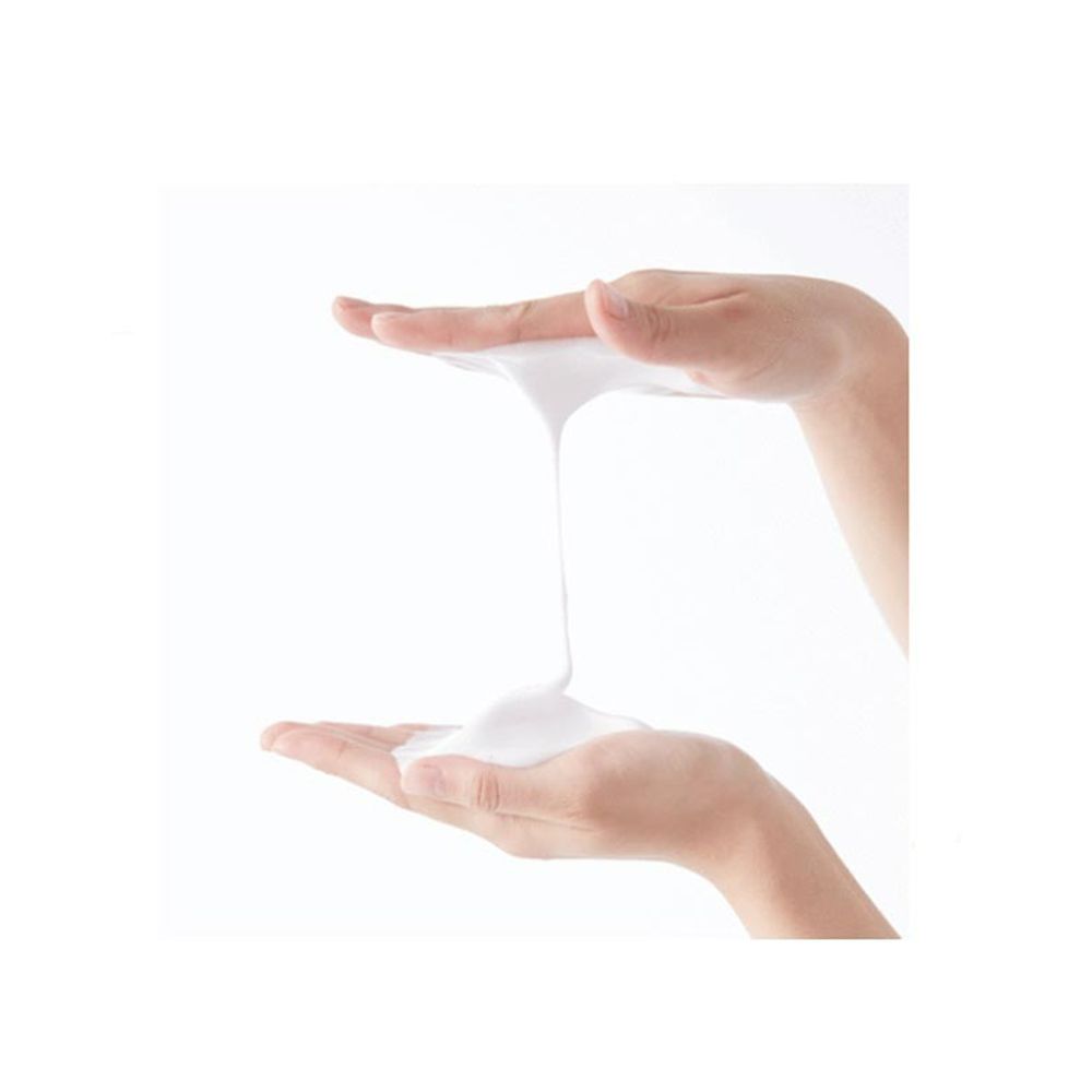 Mani che tengono schiuma bianca. La schiuma è cremosa e scorre tra le mani.