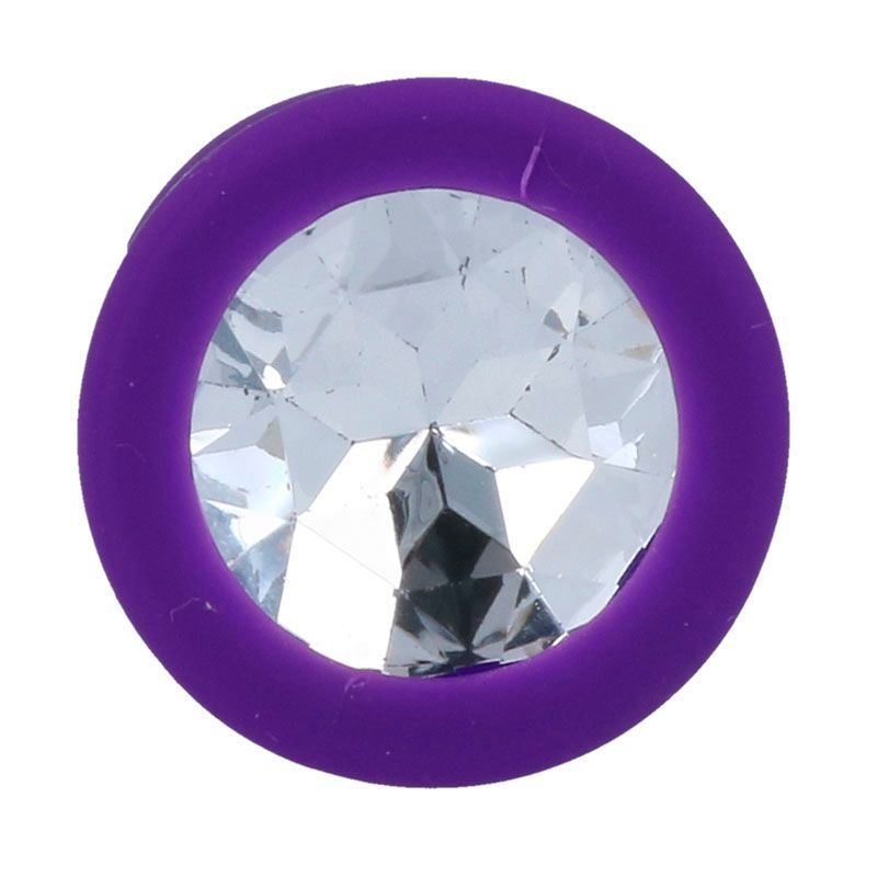 Primo piano della flangia di un plug anale viola con un grande cristallo trasparente.