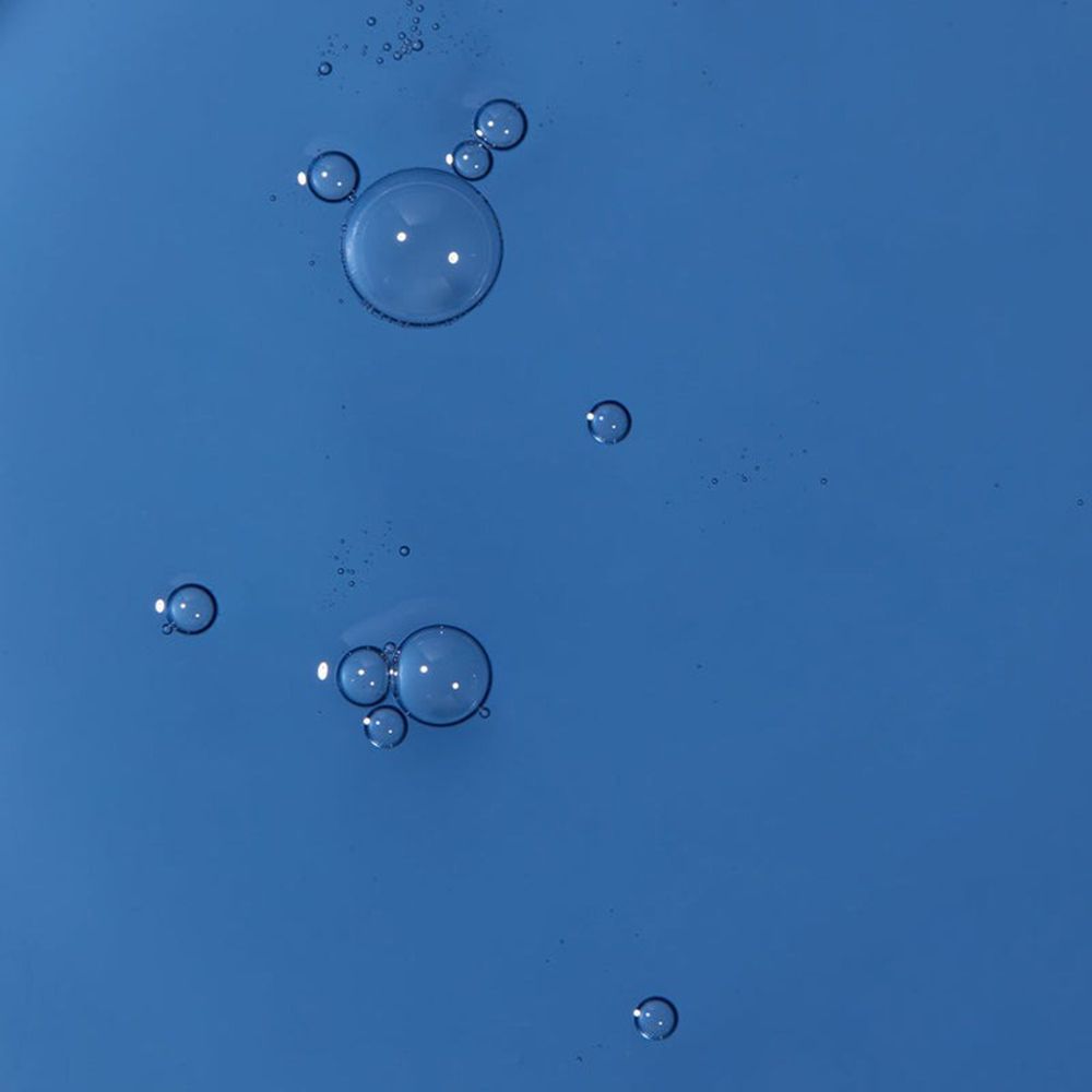 Primo piano di bolle di liquido blu. Alcune bolle sono più grandi di altre.