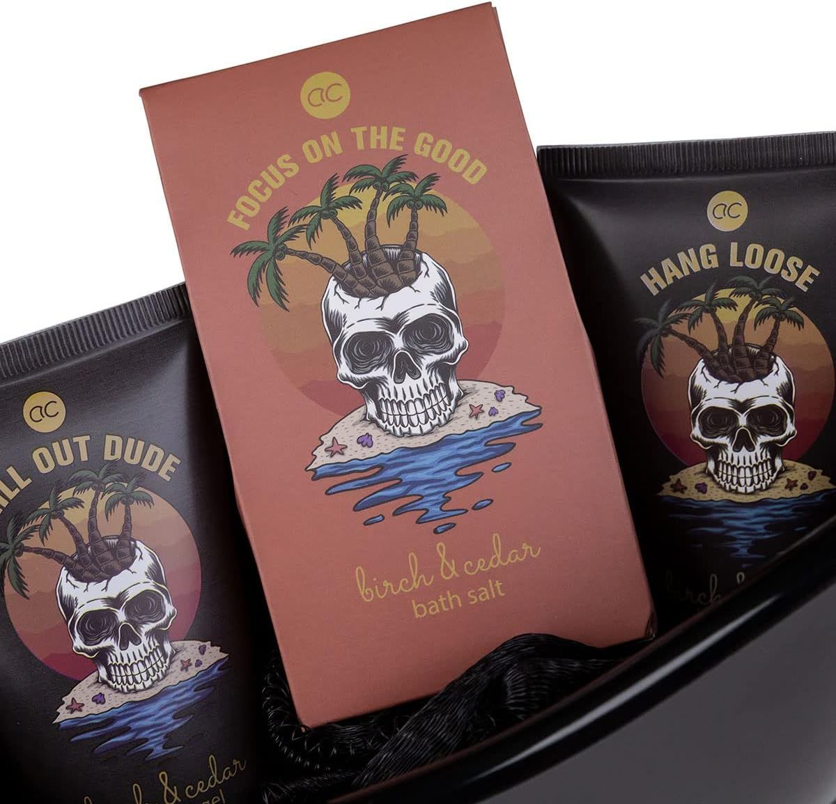 Primo piano di gel doccia, sale da bagno e lozione per il corpo. Illustrazioni di teschi e palme. Testo: birch & cedar.