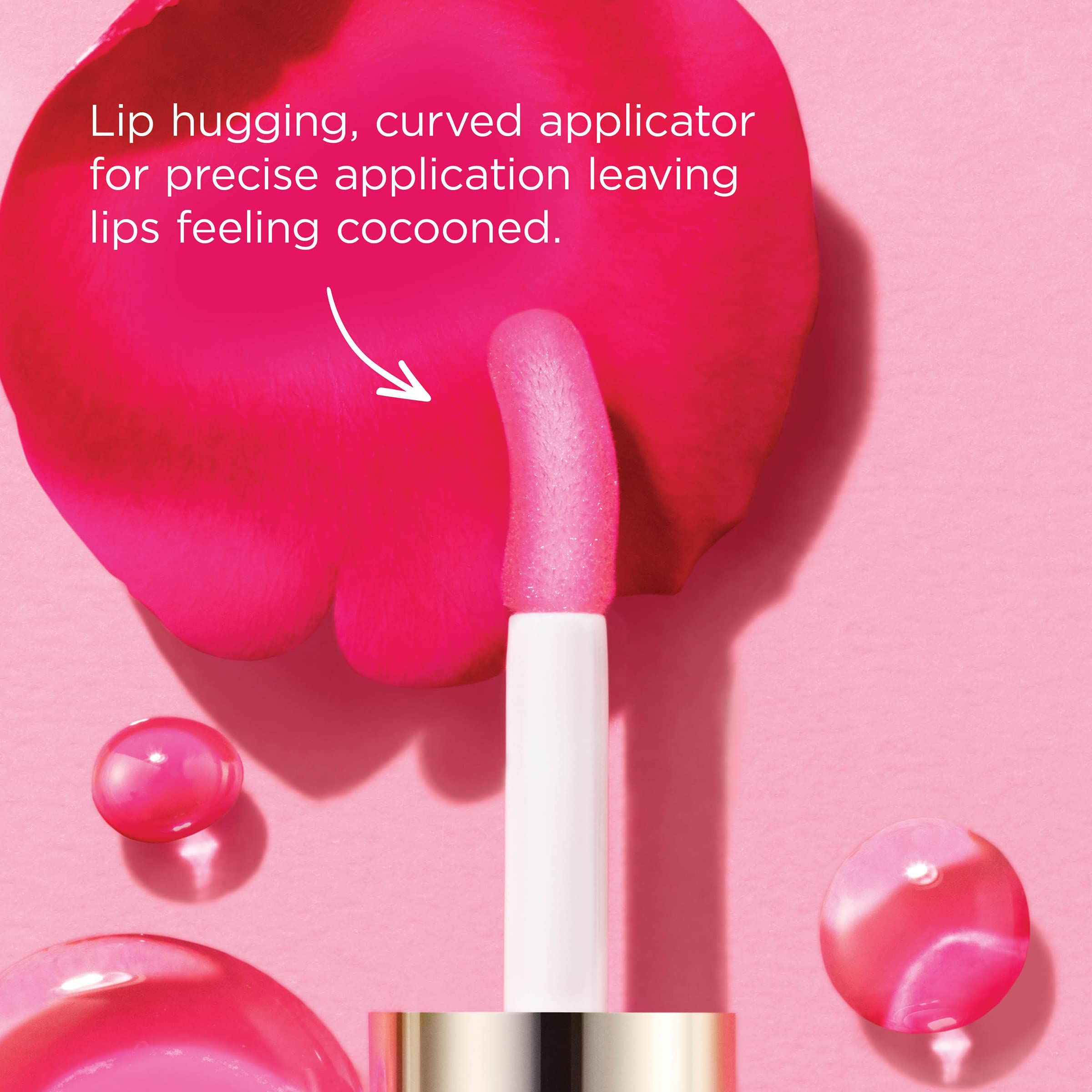 Primo piano di un applicatore di olio per labbra. Testo: Lip hugging, curved applicator. Su petali rosa.