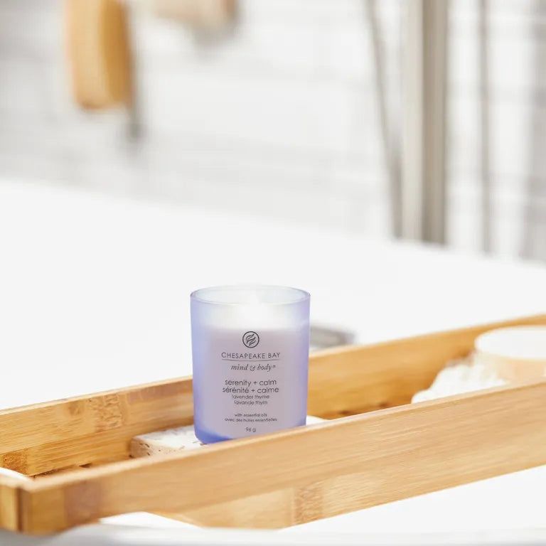 Candela in vetro blu su vassoio da bagno. Scritta: Chesapeake Bay, mind & body, serenity + calm, lavanda timo, con oli essenziali, 96 g.