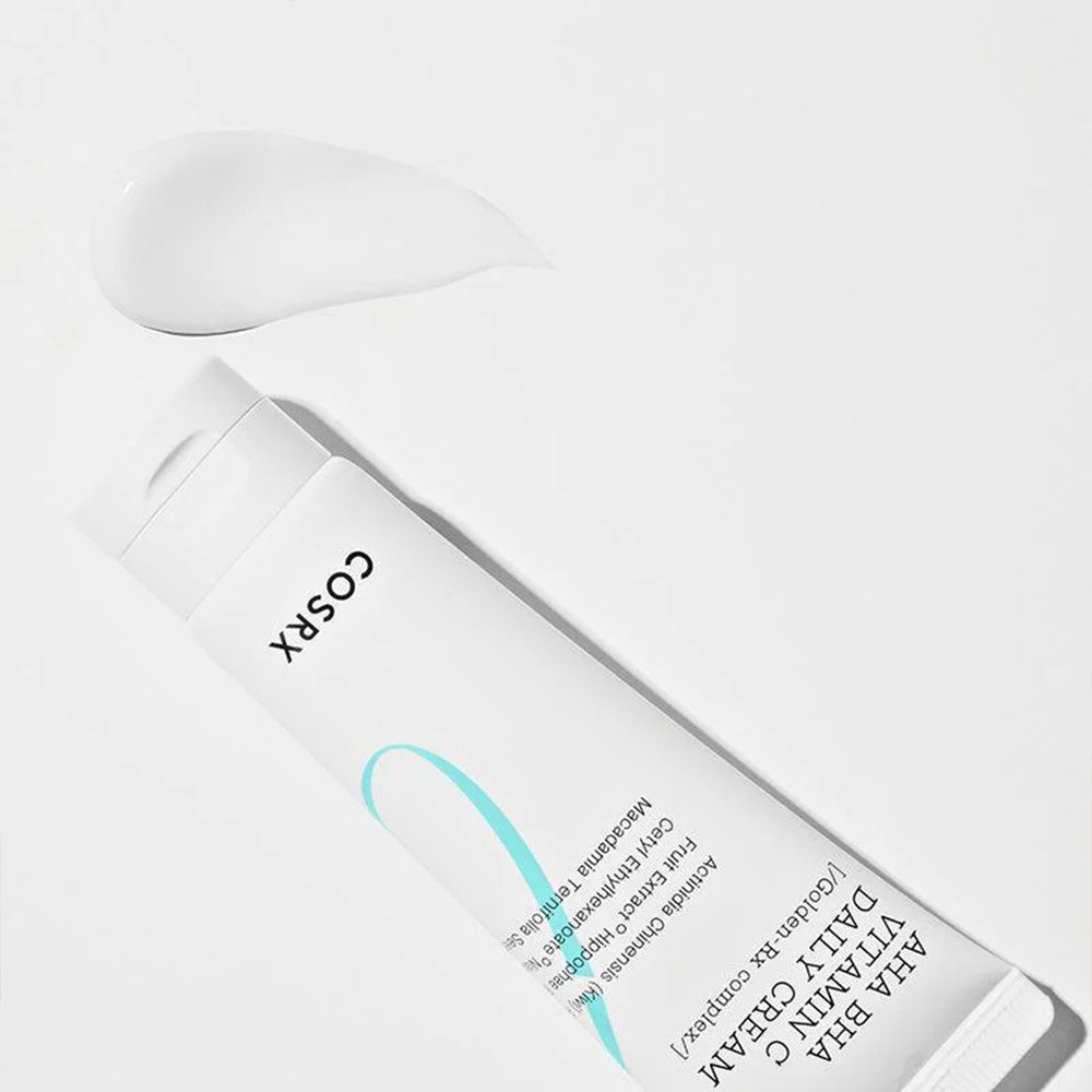Tubo COSRX AHA BHA Vitamin C Daily Cream con un campione di crema accanto.