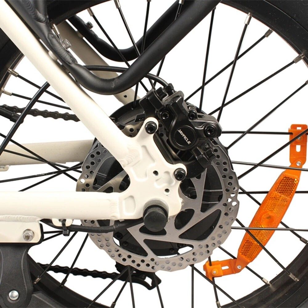 Primo piano della ruota posteriore con disco freno e catarifrangenti. Componenti neri.