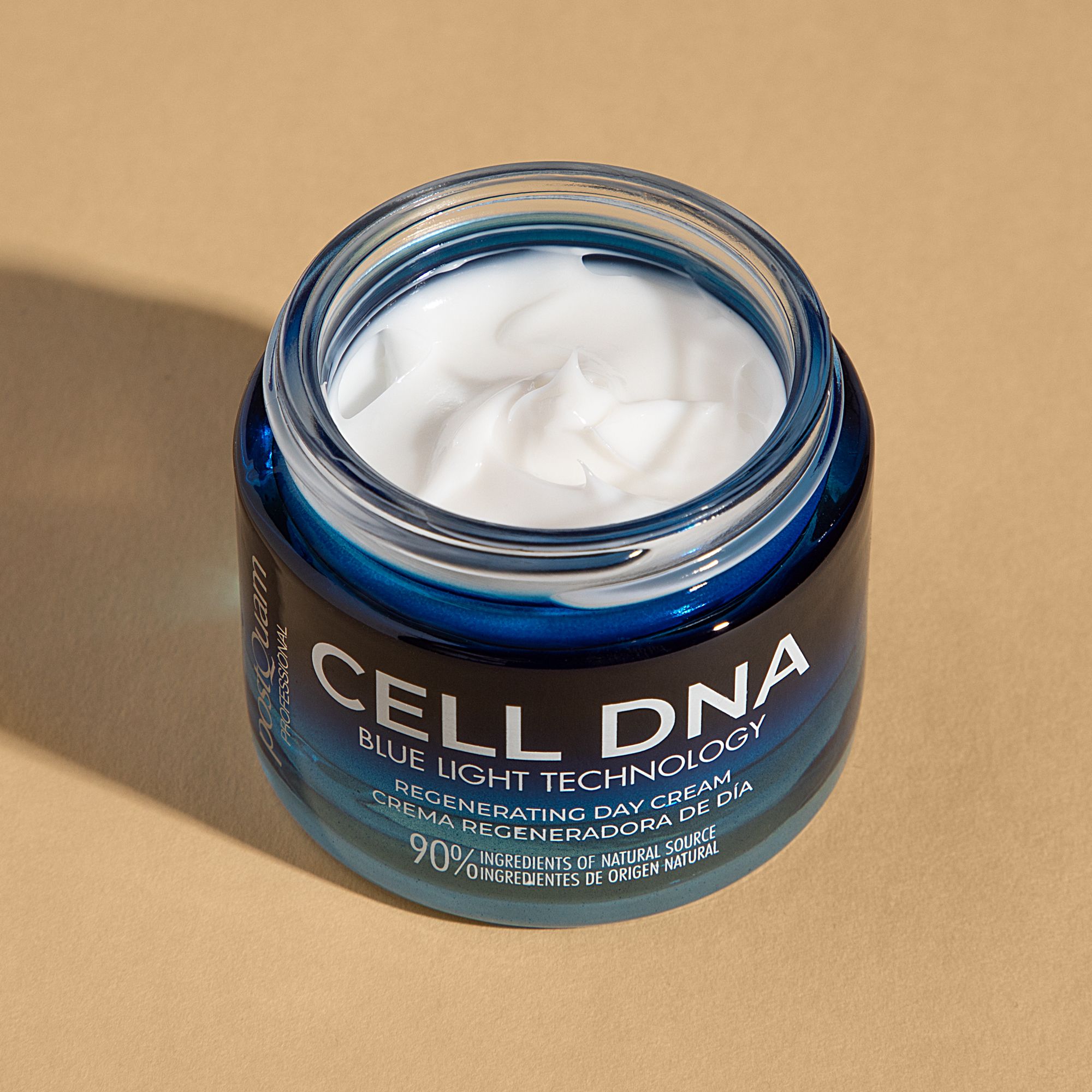 Crema giorno Postquam Cell DNA aperta. Vasetto di vetro blu con crema bianca. Scritta: CELL DNA, Blue Light Technology, Regenerating Day Cream.