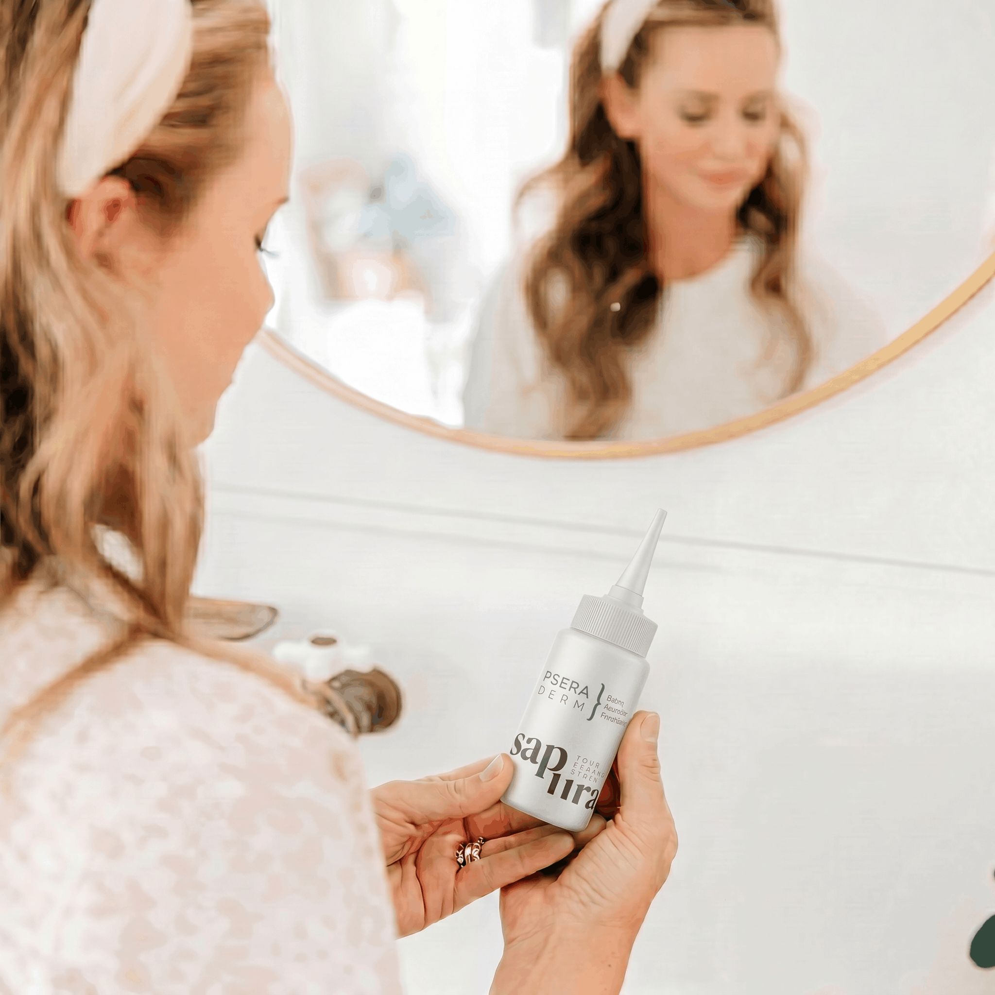 Una donna tiene un dispenser con applicatore davanti a uno specchio.