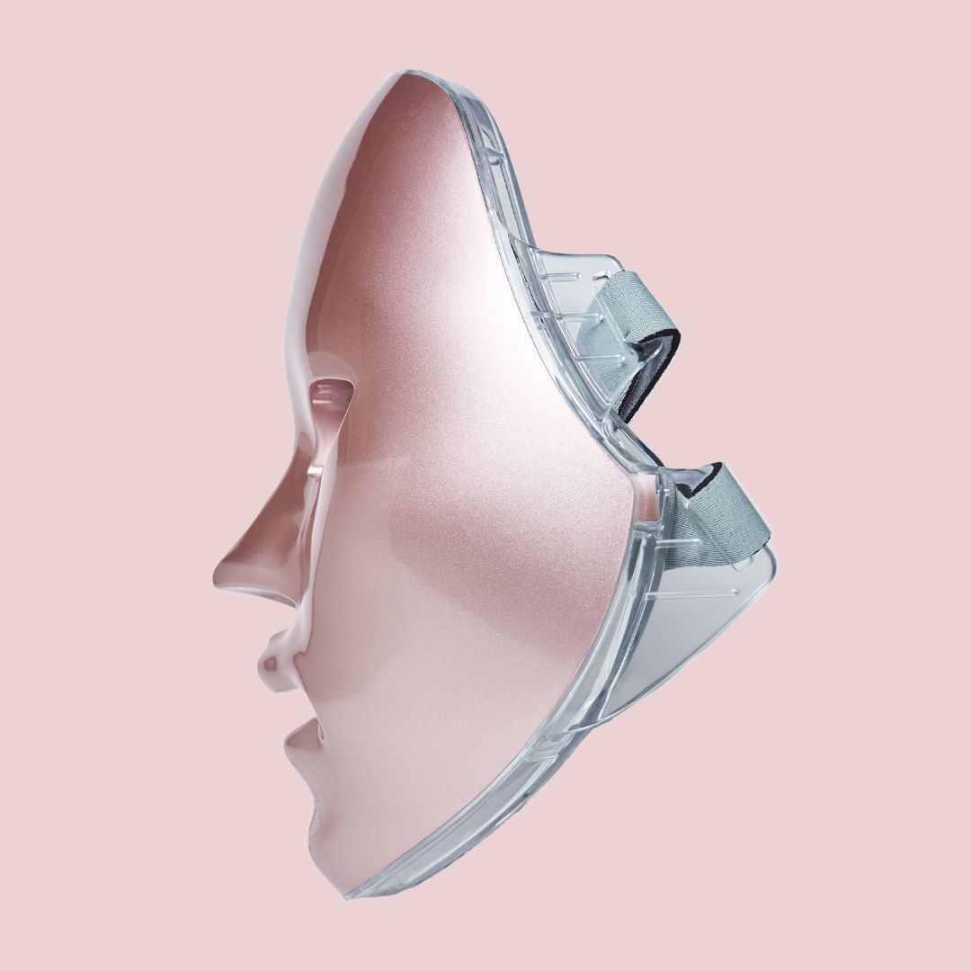 Maschera facciale a LED rosa con supporti trasparenti. La maschera ha aperture per occhi, naso e bocca. Vista laterale.