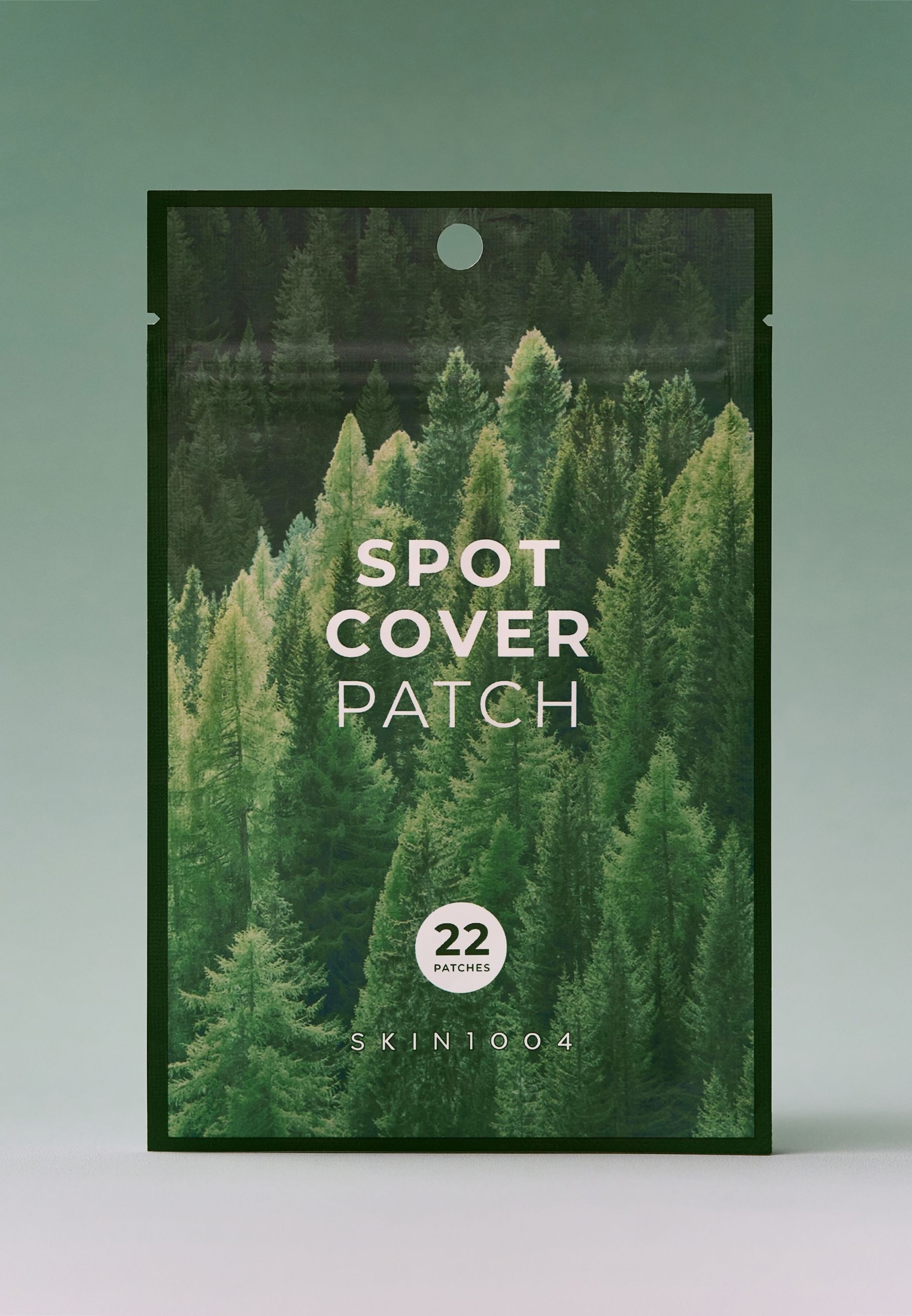 Busta con scritta « SPOT COVER PATCH ». Contiene 22 patch. Marchio: SKIN1004. Sfondo: foresta.