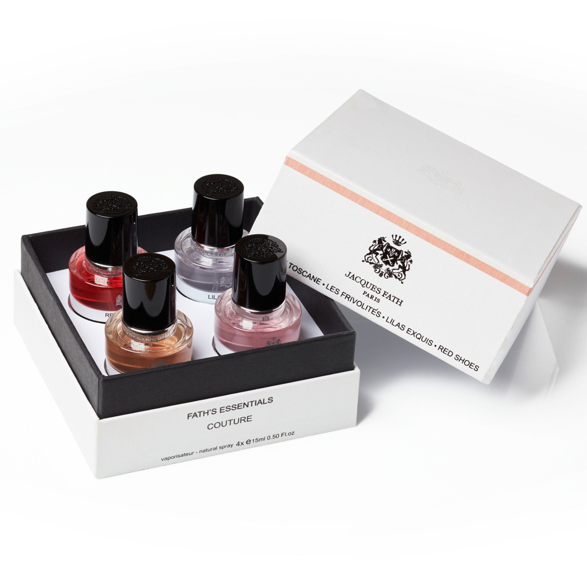 Confezione regalo con quattro flaconi di profumo. Tappi neri, liquidi colorati. Scritta Fath's Essentials Couture. Scatola aperta.