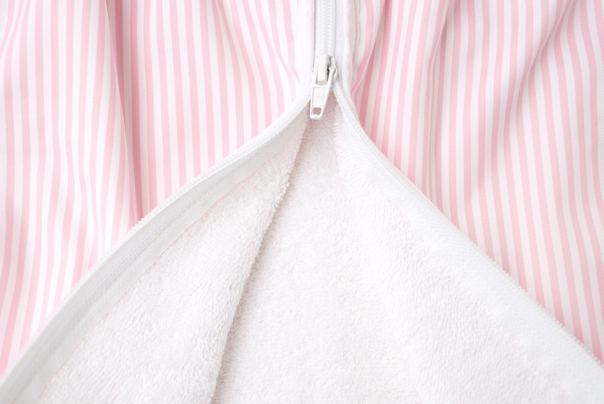 Primo piano della cerniera di un sacco nanna a righe rosa. Interno in spugna bianca.