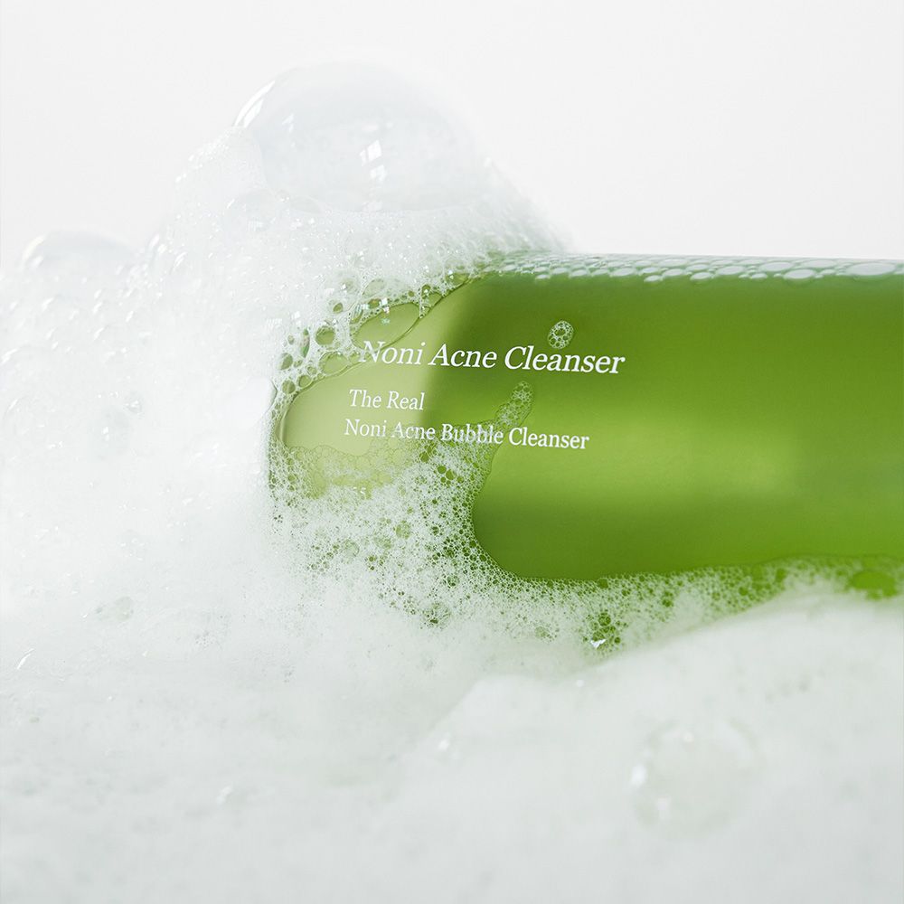 Primo piano del detergente schiumogeno anti-acne Celimax Noni in abbondante schiuma con bolle.
