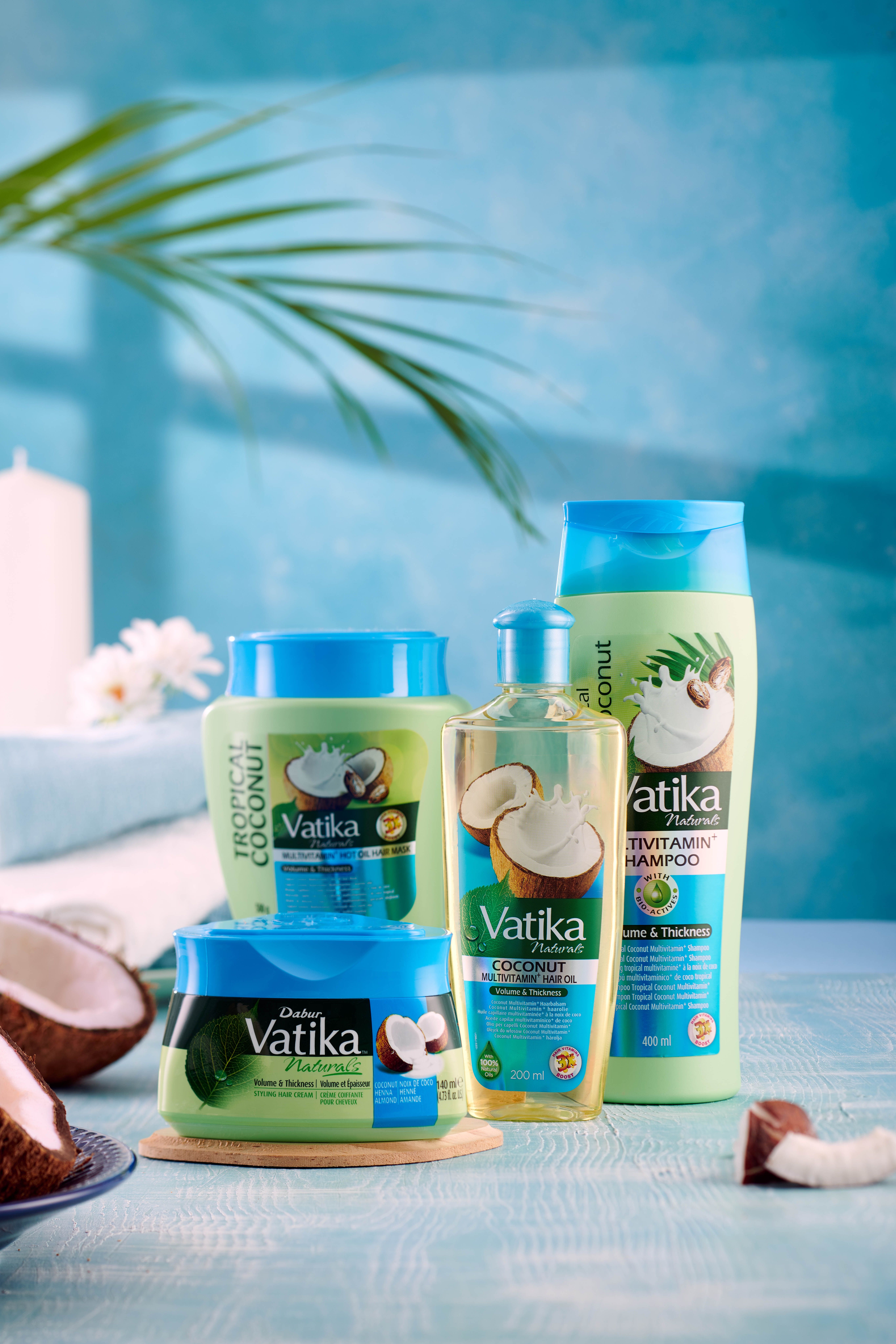 Gamma di prodotti Vatika Naturals: olio per capelli, shampoo e creme. Scritta: Coconut. Confezioni blu e verdi. Illustrazioni di cocco.