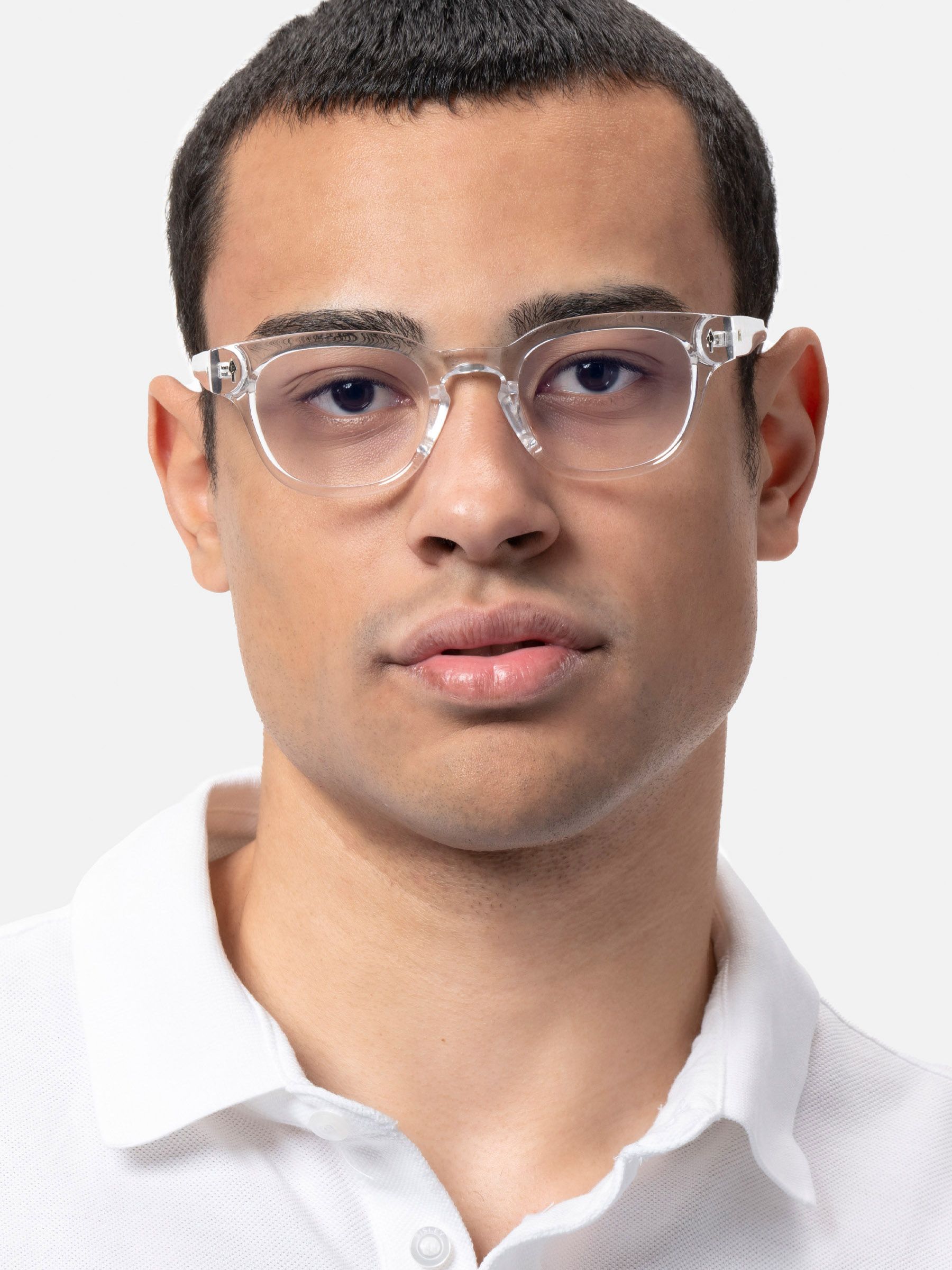 Uomo con occhiali trasparenti. Gli occhiali hanno lenti rotonde e montatura trasparente. Camicia bianca.