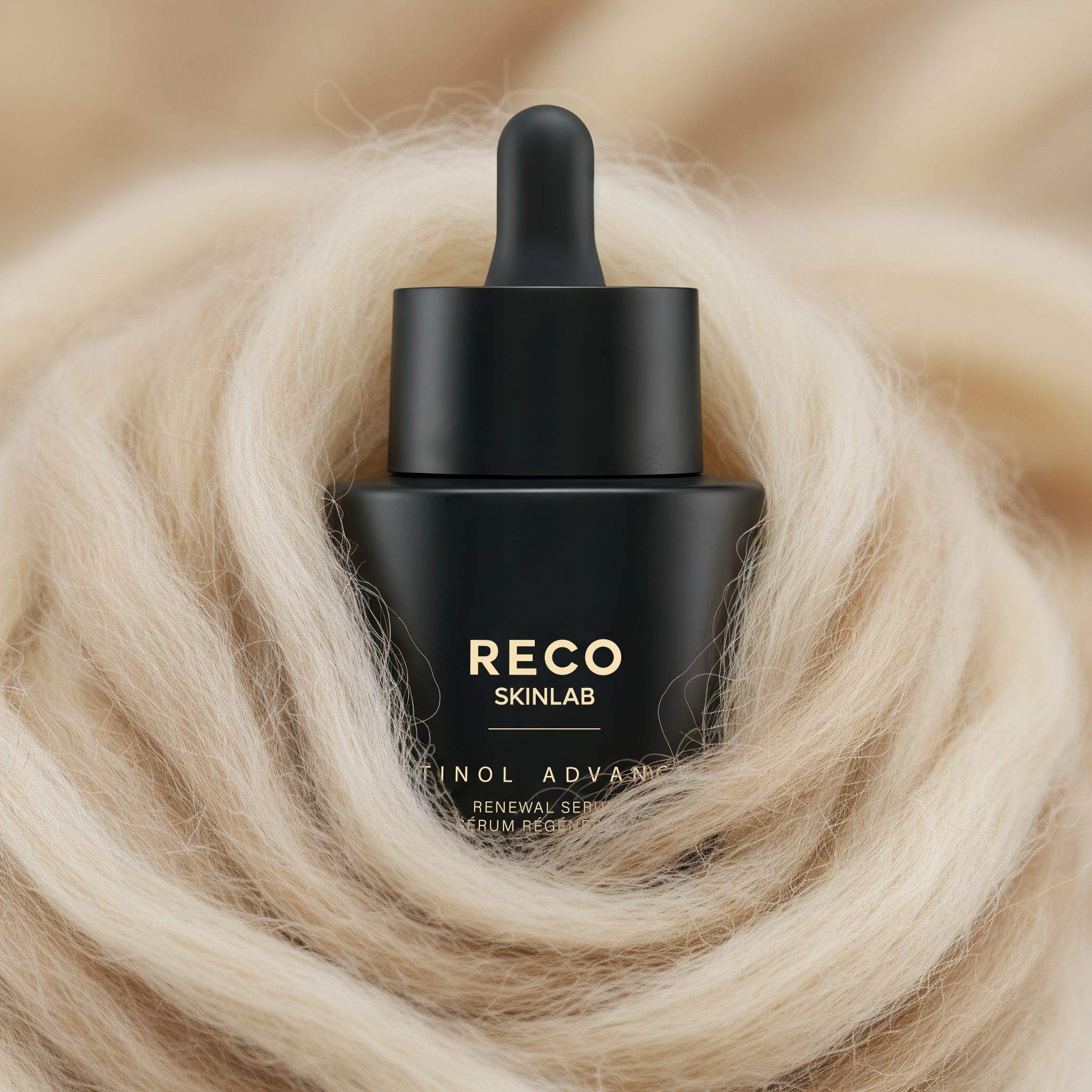 Flacone nero con contagocce, circondato da materiale chiaro e soffice. Scritta: RECO SKINLAB, Retinol Advanced Serum.