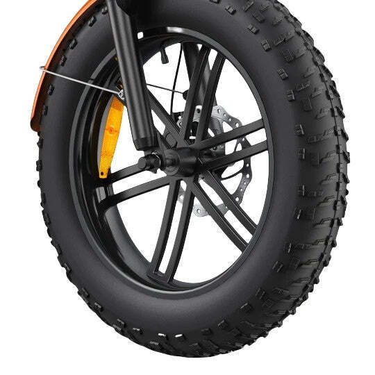 Primo piano di uno pneumatico nero per bicicletta. Cerchio nero con raggi, disco freno e parafango arancione.