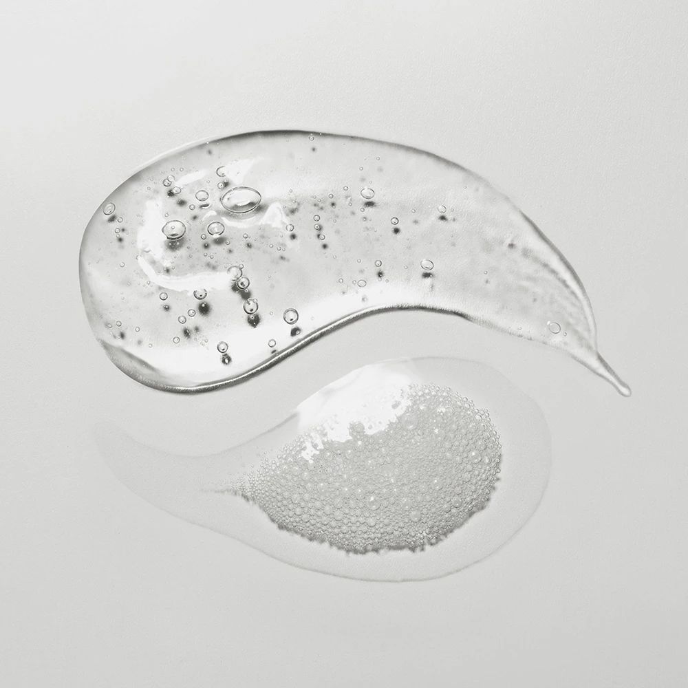 Due gocce di gel trasparente. Una con bolle. Su sfondo chiaro.