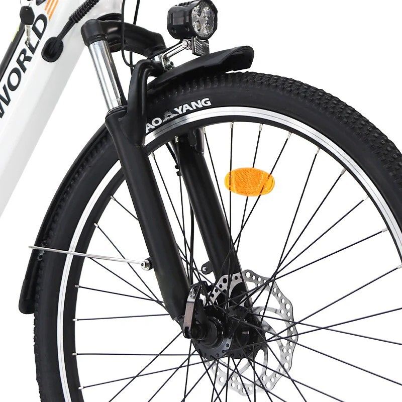 Primo piano della ruota anteriore di una bicicletta elettrica bianca. Forcella nera, faro e disco freno.