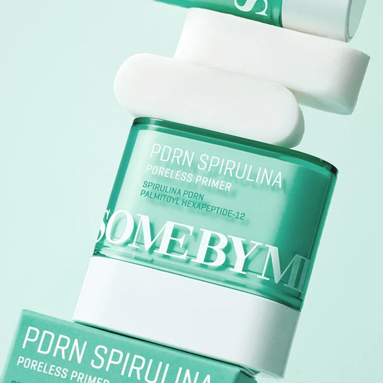 Molti contenitori SOME BY MI PDRN Spirulina Poreless Primer e bastoncini bianchi, impilati e disposti diagonalmente.