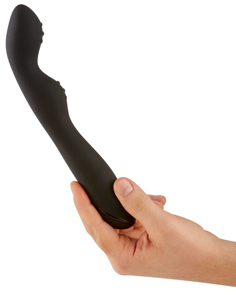 Vibratore nero tenuto in mano. Forma curva con rilievi.