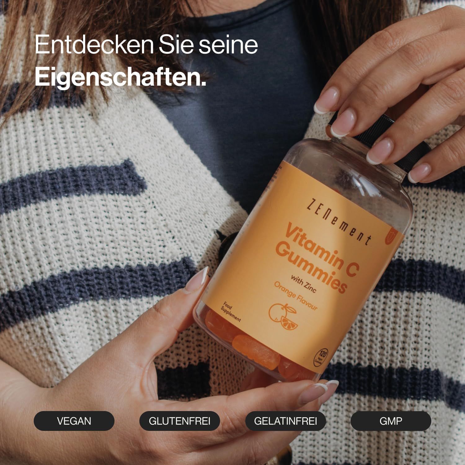 Donna che tiene in mano un flacone di caramelle gommose Zenement Vitamina C. Testo: Vitamin C Gummies with Zinc, Orange Flavor. Vegano, senza glutine, senza gelatina, GMP.