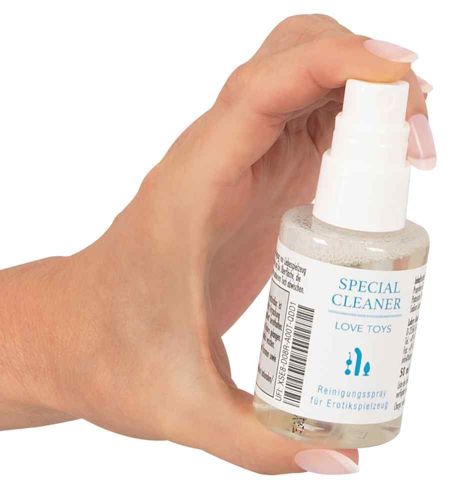 Piccolo flacone trasparente con erogatore bianco, tenuto in mano. Scritta: SPECIAL CLEANER LOVE TOYS. Spray detergente.