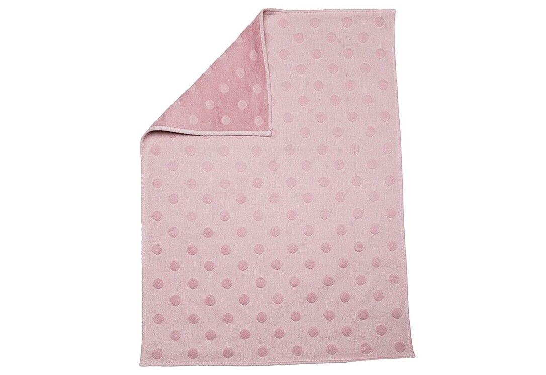 Coperta rosa, parzialmente ripiegata, mostra un lato più chiaro. Motivo a pois. Rettangolare.