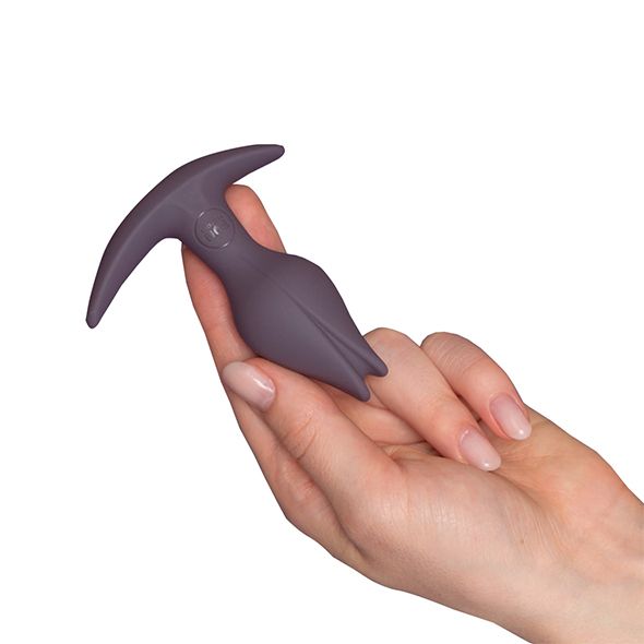 Butt plug viola scuro tenuto in mano. Impugnatura a T, testa a forma di tulipano.