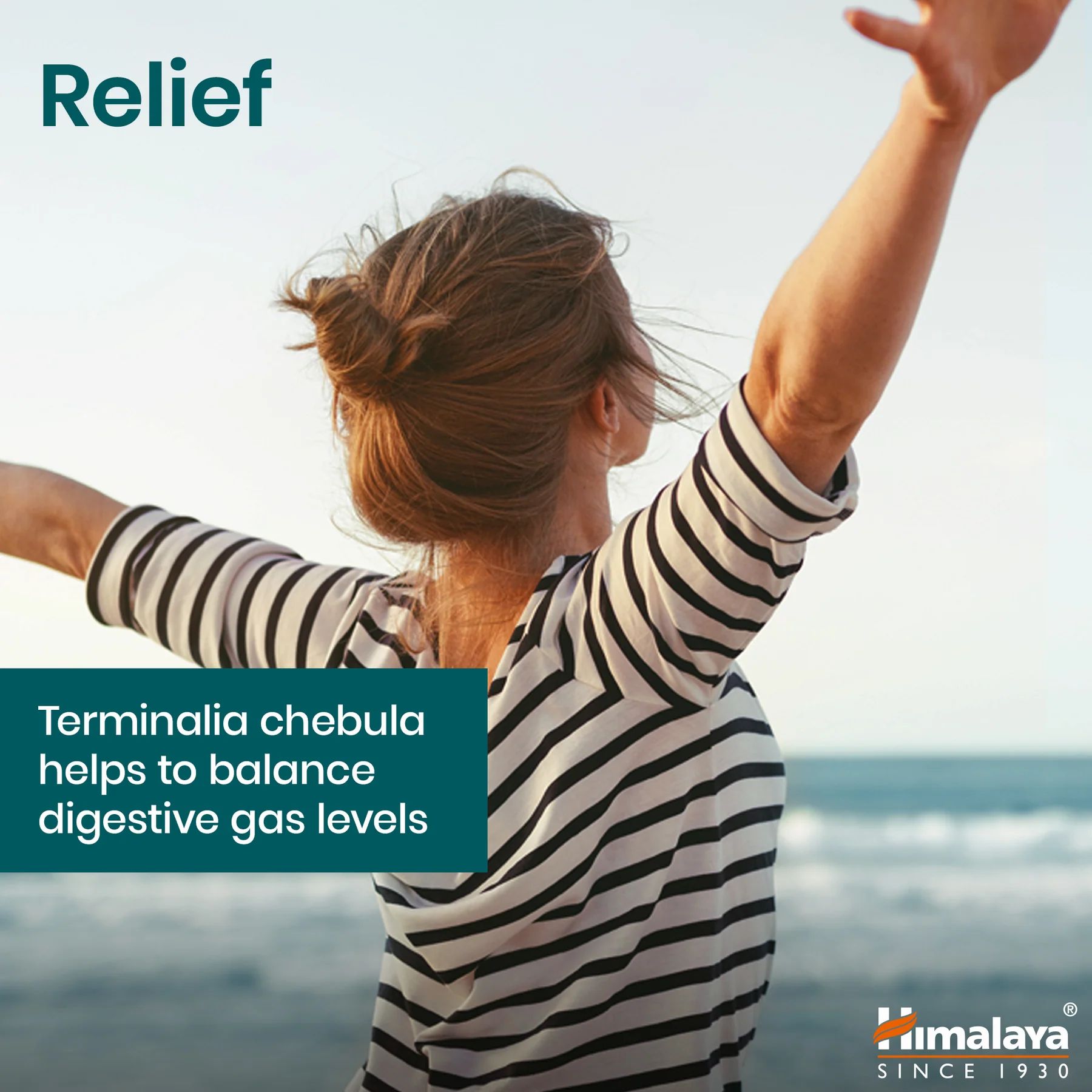 Donna con le braccia alzate sulla spiaggia. Testo: Terminalia chebula aiuta a bilanciare i gas digestivi.