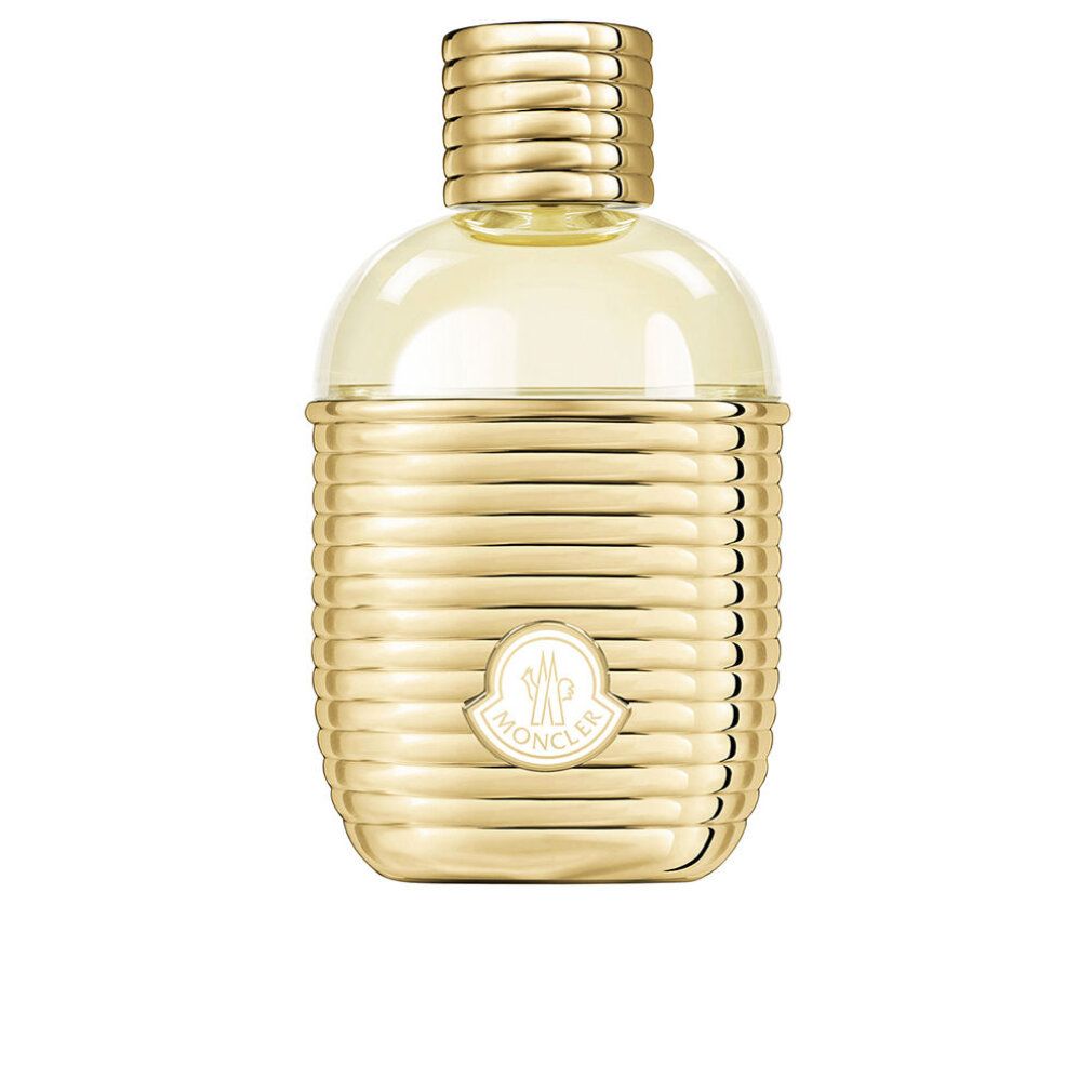 Flacone dorato con superficie scanalata e logo Moncler. Tappo e collo dorati. Contenuto trasparente e giallastro.