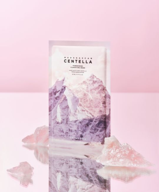 Confezione maschera Madagascar Centella con motivo montuoso. Sfondo rosa e cristalli.