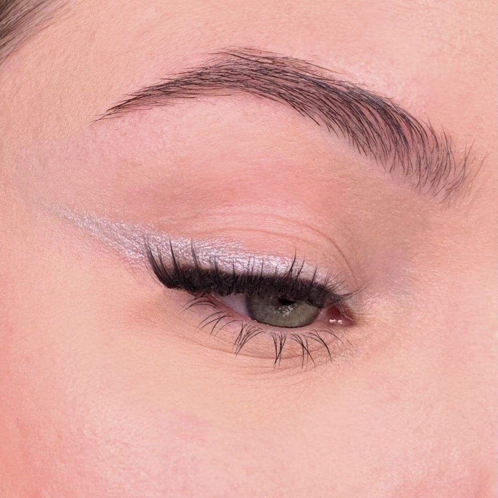 Occhio con eyeliner argentato. Ciglia e sopracciglia visibili. Tonalità della pelle rosata.