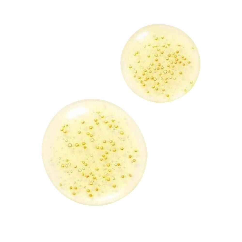 Due gocce giallastre con piccole sfere dorate. Su sfondo bianco.