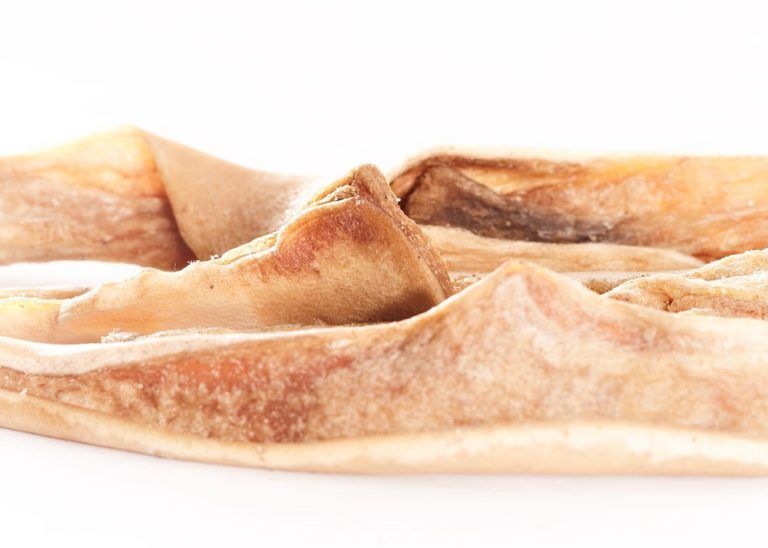 Primo piano di pezzi di pelle essiccata beige-marrone. La forma e la consistenza irregolari sono chiaramente visibili.