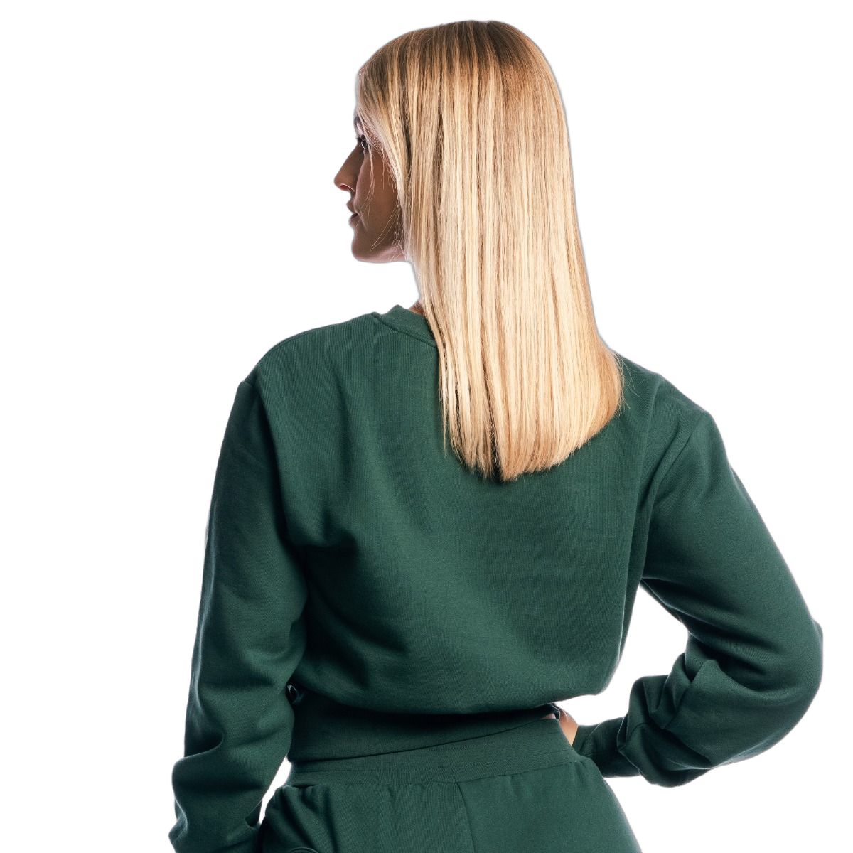 Vista posteriore di una donna con maglione cropped da donna verde a maniche lunghe Forest. Capelli biondi lunghi.