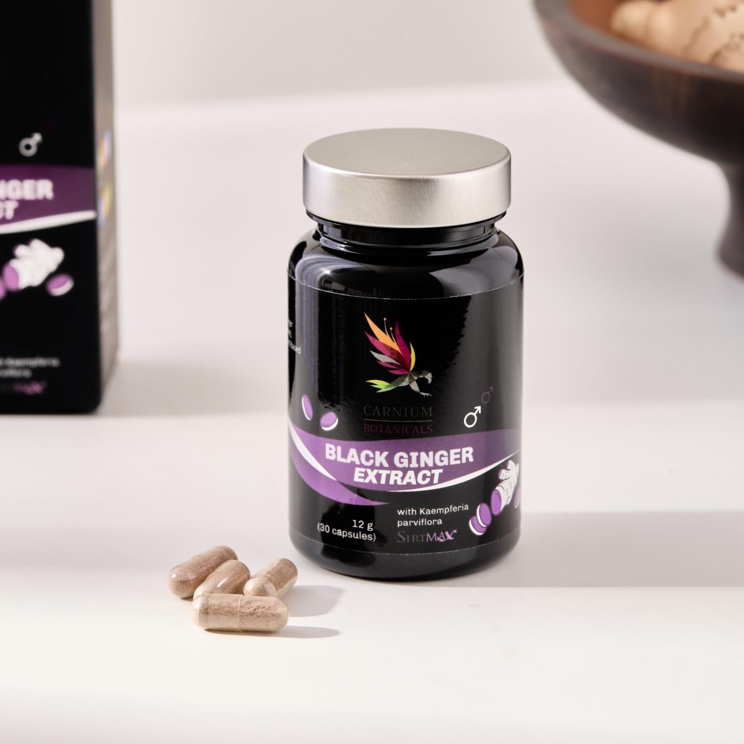 Flacone nero con tappo argentato. Scritta: Black Ginger Extract. Capsule accanto. Marchio: Carnium Botanicals.