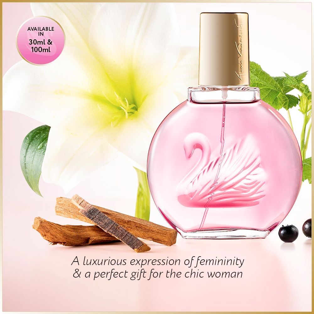 Flacone di profumo rosa con tappo dorato, motivo cigno. Sfondo con fiori e legno.