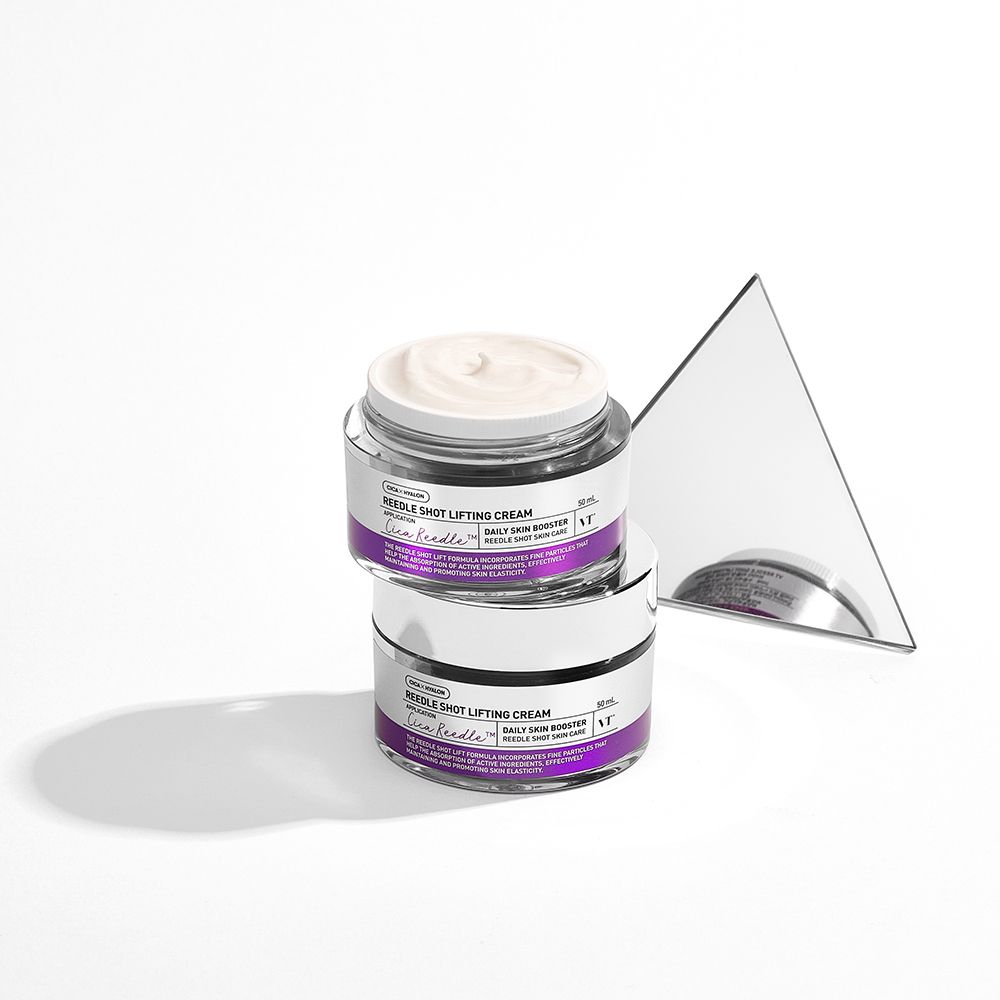 Due vasetti di vetro con crema, impilati. Coperchi argentati, dettagli viola. Accanto c'è uno specchio triangolare.